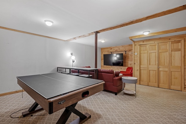 recreation room with beamed ceiling, light carpet, and wood walls