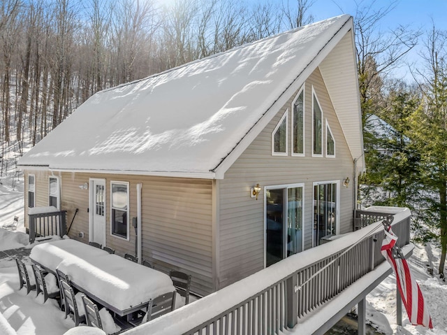 snow covered property with a deck