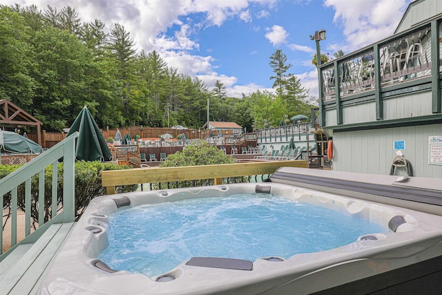 view of pool with a wooden deck and a hot tub