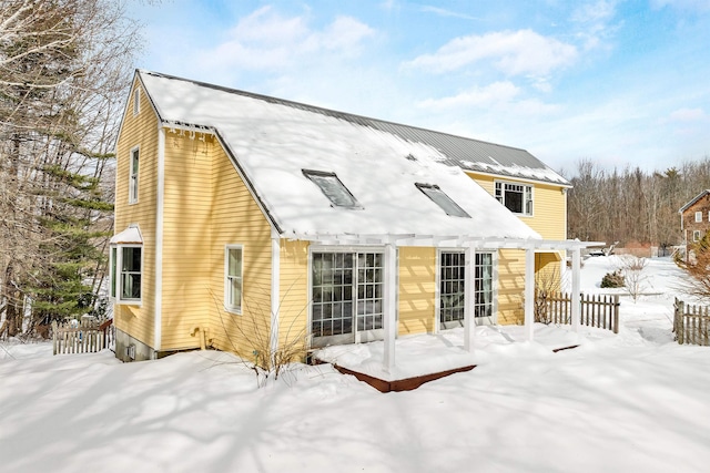 snow covered property featuring a pergola