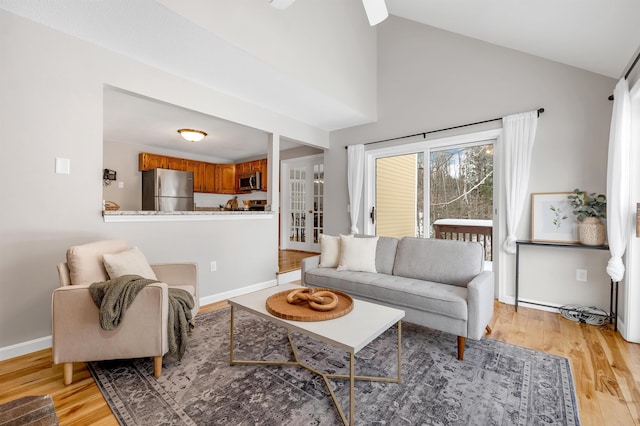 living room with high vaulted ceiling and light hardwood / wood-style floors