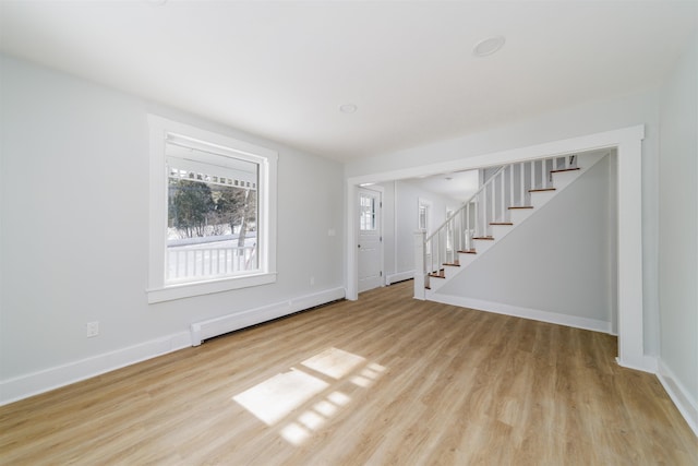 unfurnished living room featuring light hardwood / wood-style flooring and baseboard heating