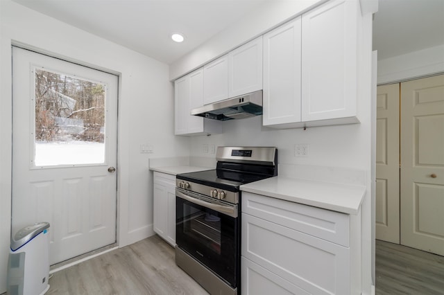 kitchen with white cabinets, light wood-type flooring, and stainless steel range with electric stovetop