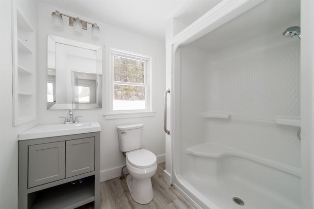 bathroom with vanity, wood-type flooring, toilet, and walk in shower