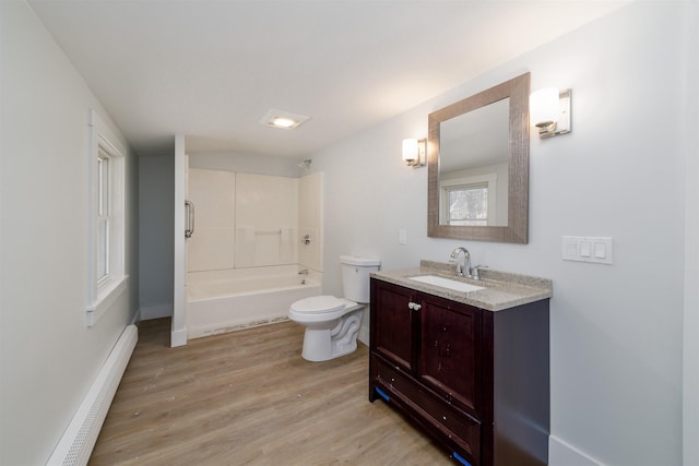 full bathroom with hardwood / wood-style floors, vanity, a baseboard heating unit,  shower combination, and toilet