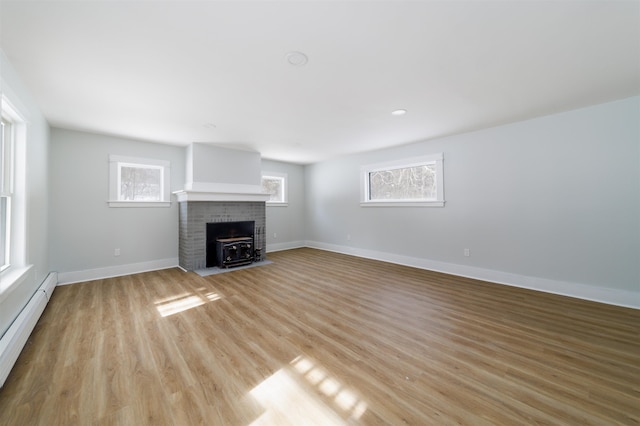 unfurnished living room with a baseboard radiator and light hardwood / wood-style flooring