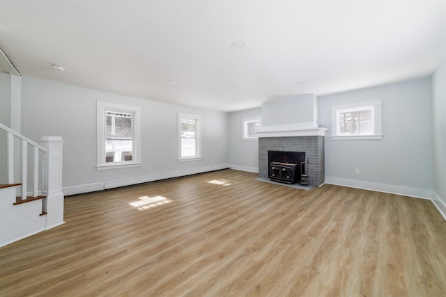 unfurnished living room featuring a baseboard radiator and light hardwood / wood-style flooring