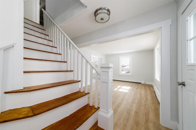 stairs featuring hardwood / wood-style floors and baseboard heating