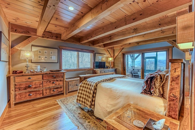 bedroom featuring beam ceiling, light hardwood / wood-style floors, multiple windows, and access to outside