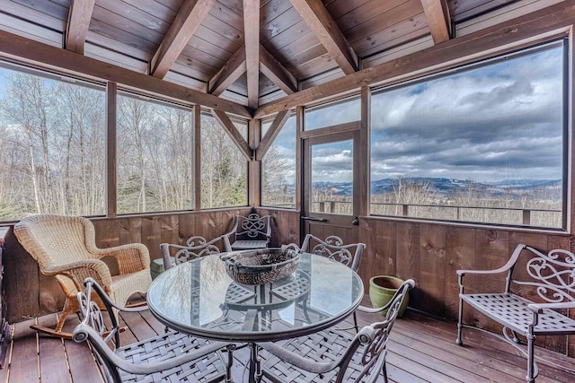 sunroom / solarium featuring beamed ceiling, a mountain view, and wooden ceiling