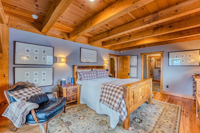 bedroom with beamed ceiling, wooden ceiling, and light wood-type flooring