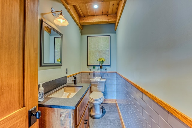 bathroom with tile walls, vanity, wood ceiling, toilet, and beam ceiling