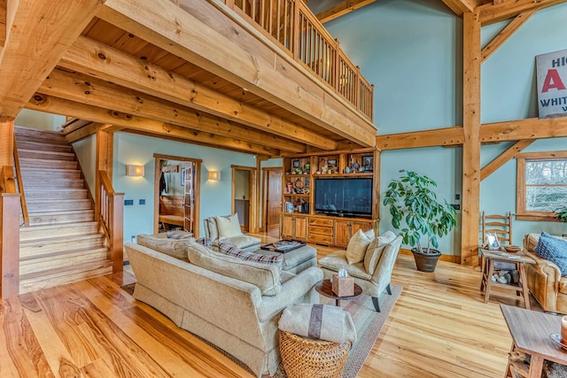 living room with a towering ceiling and light wood-type flooring