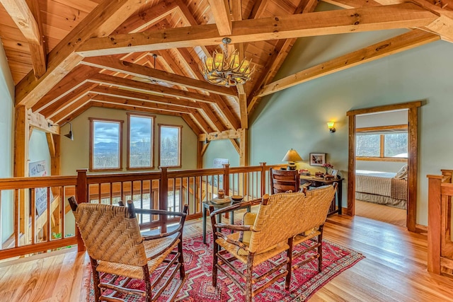 sitting room featuring a chandelier, light hardwood / wood-style floors, and vaulted ceiling with beams