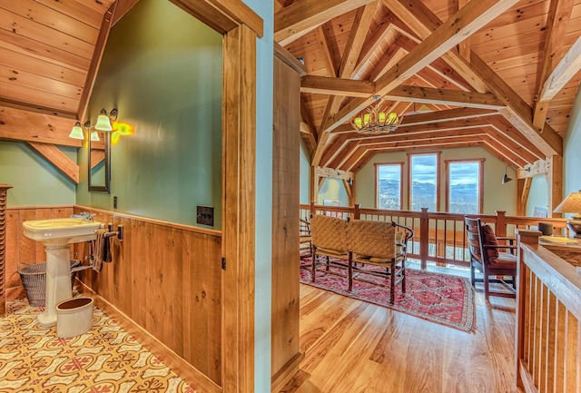 bathroom featuring vaulted ceiling with beams, wood ceiling, an inviting chandelier, wooden walls, and hardwood / wood-style flooring