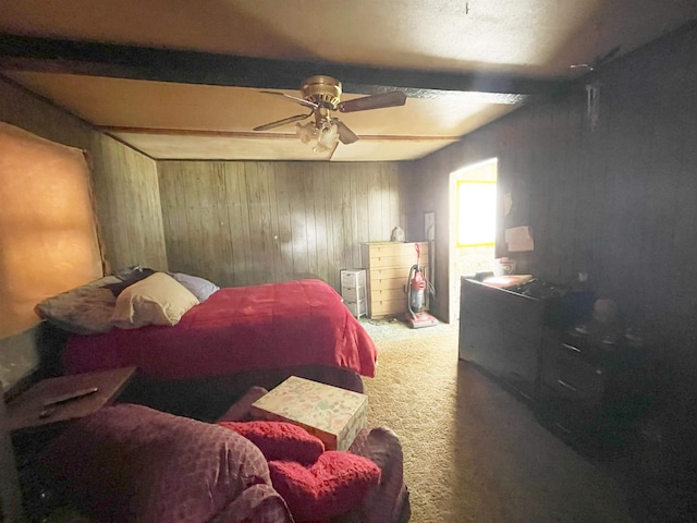 bedroom featuring beam ceiling, wood walls, ceiling fan, and carpet flooring