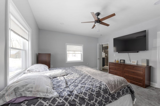 bedroom featuring stainless steel fridge, ceiling fan, carpet flooring, and multiple windows