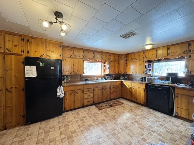 kitchen featuring pendant lighting, sink, and black appliances