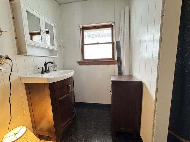 bathroom with vanity and wood walls