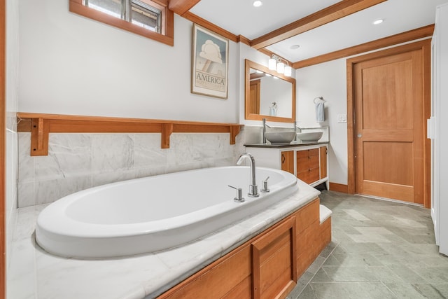 bathroom featuring beamed ceiling, vanity, and a tub