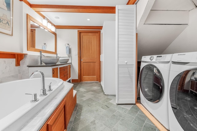 clothes washing area featuring sink and washer and dryer