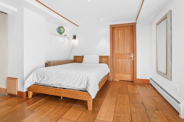 bedroom with hardwood / wood-style flooring and a baseboard radiator