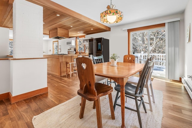 dining area with wood ceiling, beam ceiling, and light hardwood / wood-style floors