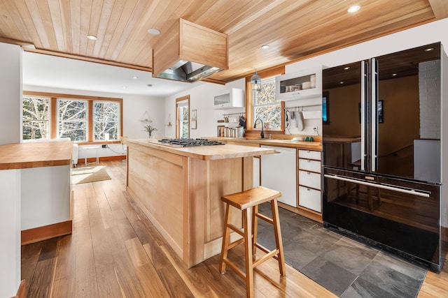 kitchen featuring black refrigerator, white cabinetry, wooden counters, and dishwasher