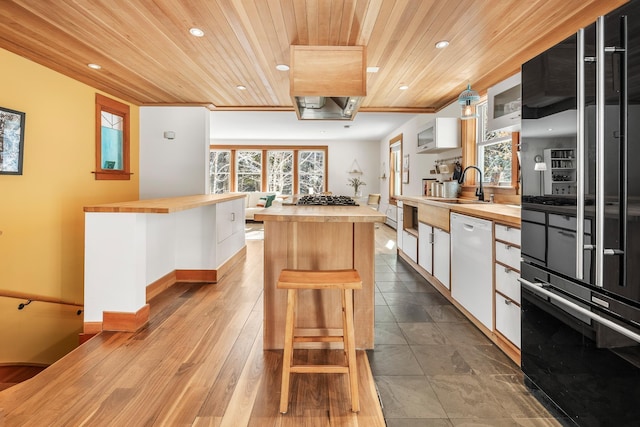 kitchen with butcher block countertops, wood ceiling, sink, white dishwasher, and white cabinets