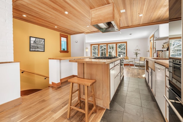 kitchen featuring a kitchen island, appliances with stainless steel finishes, white cabinets, wood ceiling, and light wood-type flooring