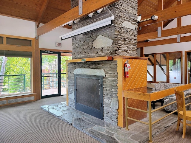 carpeted living room featuring high vaulted ceiling, beam ceiling, a stone fireplace, and wooden ceiling