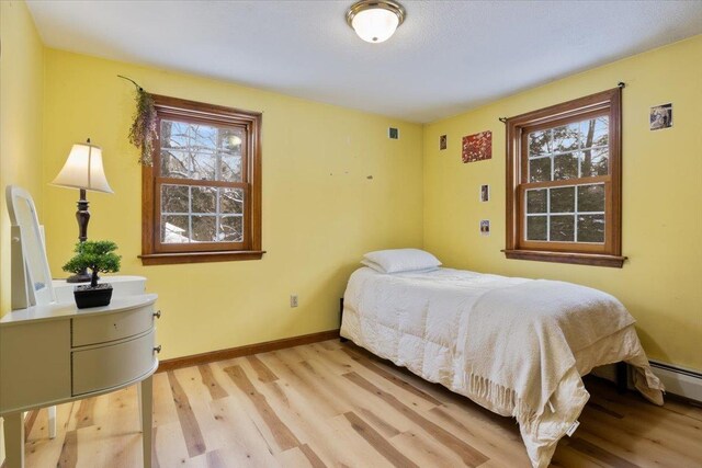 bedroom featuring multiple windows and light hardwood / wood-style floors