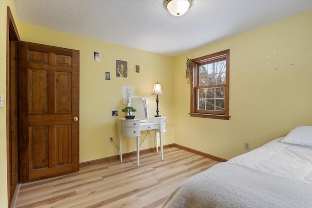 bedroom with light hardwood / wood-style flooring and a textured ceiling