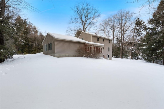 view of snow covered rear of property