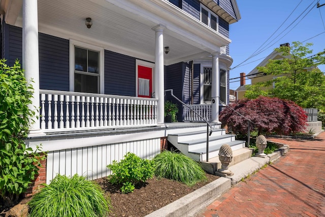 view of exterior entry featuring covered porch