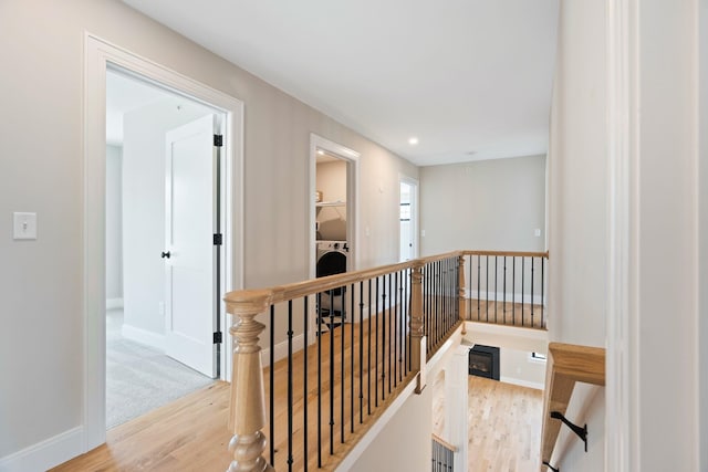 hallway featuring washer / clothes dryer and light hardwood / wood-style flooring