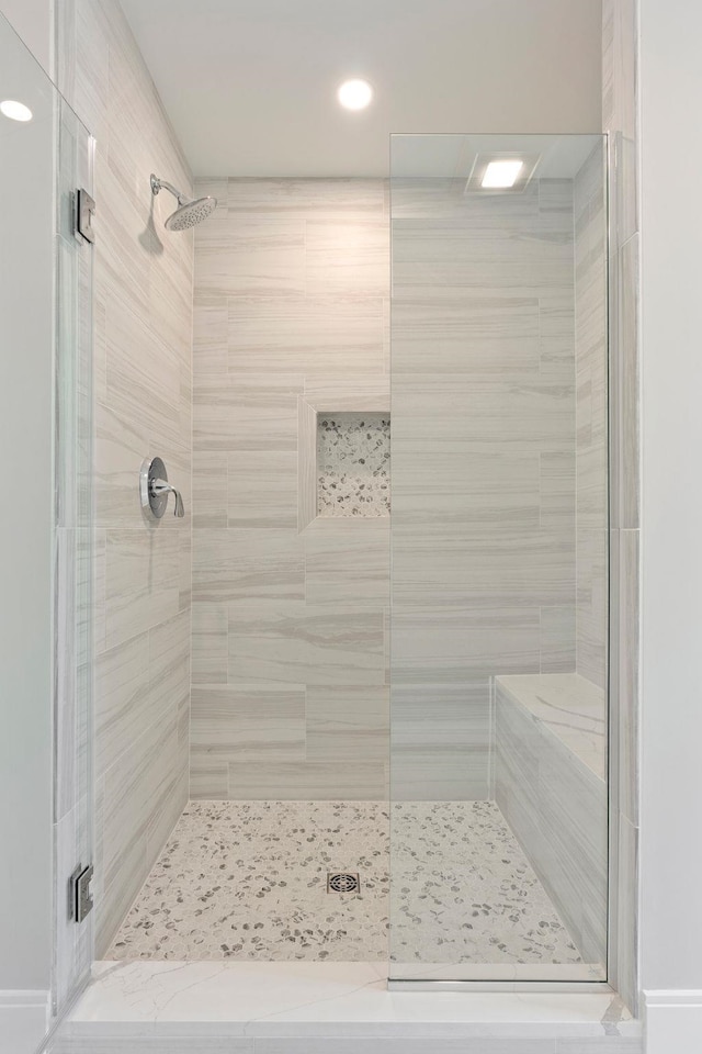 bathroom featuring a shower with door