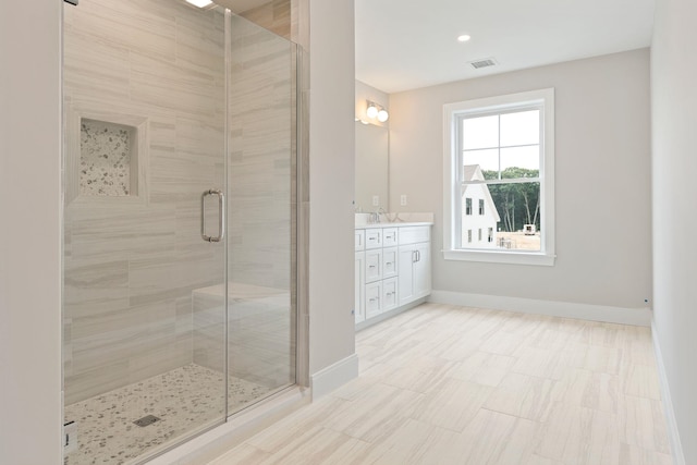 bathroom featuring vanity and a shower with door