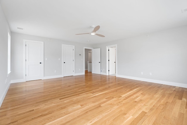 unfurnished bedroom with multiple closets, ceiling fan, and light hardwood / wood-style floors