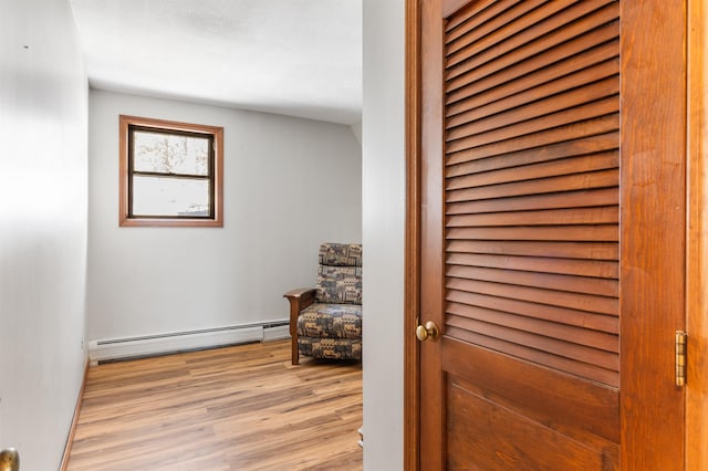 doorway featuring a baseboard heating unit and light hardwood / wood-style flooring