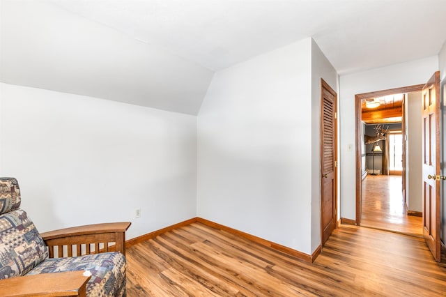 living area featuring lofted ceiling and light hardwood / wood-style floors