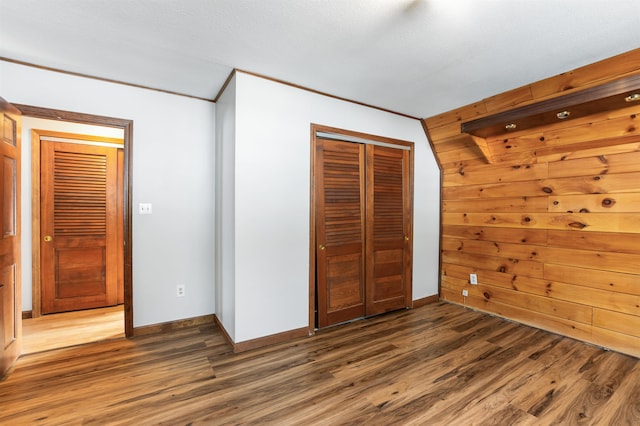 unfurnished bedroom featuring dark hardwood / wood-style flooring, crown molding, and a closet