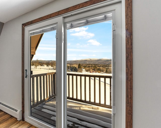 doorway with hardwood / wood-style floors and a baseboard heating unit