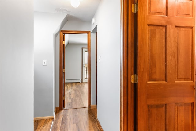 hall with a baseboard radiator and light wood-type flooring