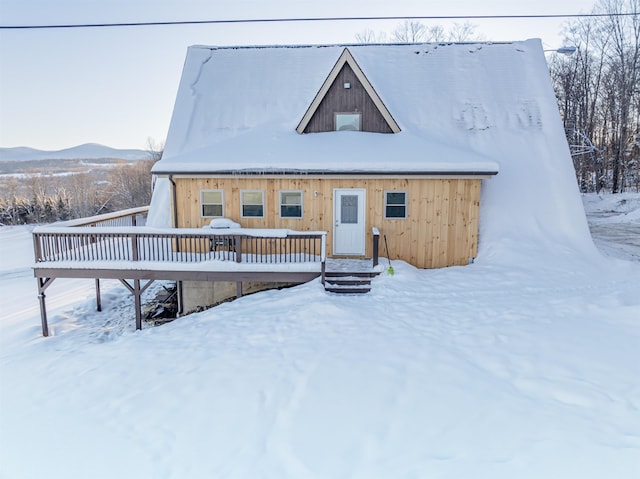 snow covered rear of property featuring a mountain view