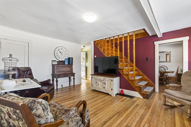 living room with light wood-type flooring and beam ceiling