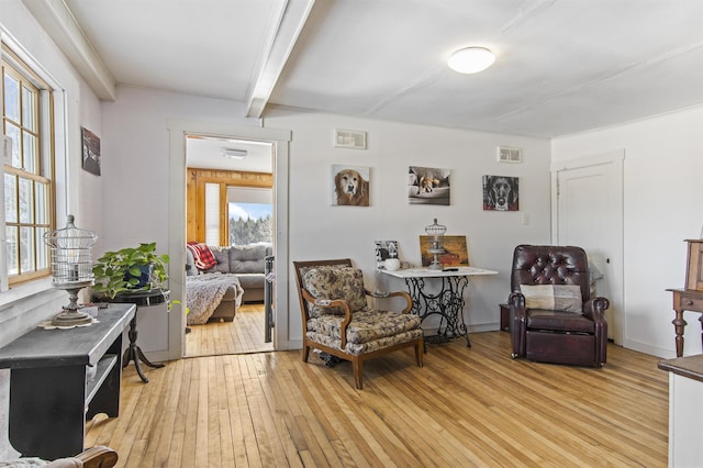 sitting room featuring light hardwood / wood-style floors and beamed ceiling