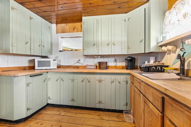 kitchen featuring decorative backsplash, sink, and butcher block countertops