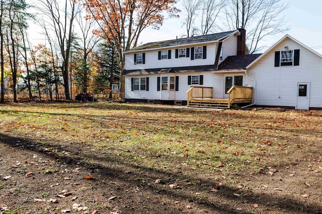 back of house featuring a wooden deck and a yard