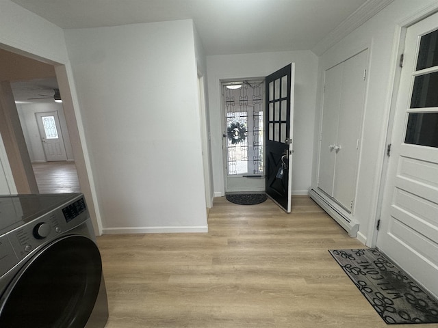 interior space with a baseboard radiator, washer / clothes dryer, and light hardwood / wood-style floors